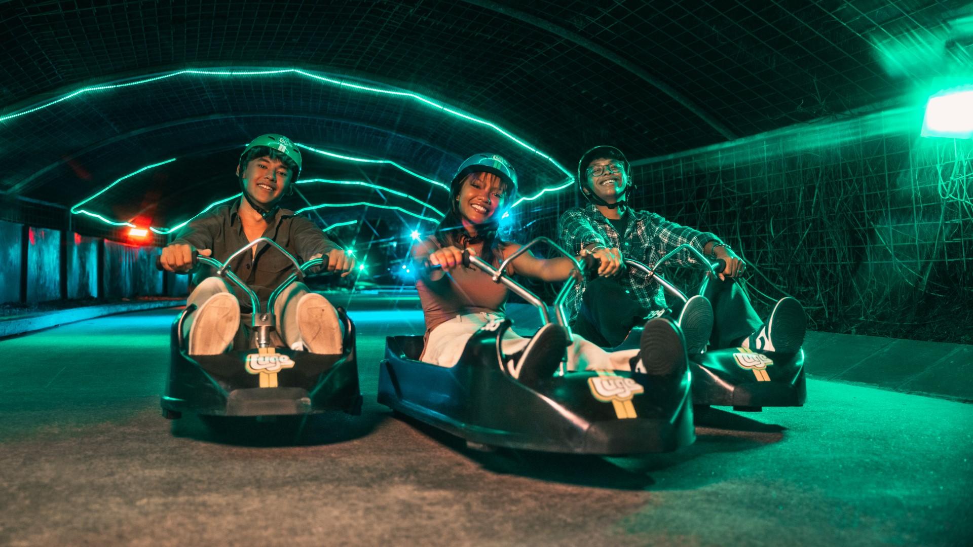 Three friends pose for a photo on the Night Luge.