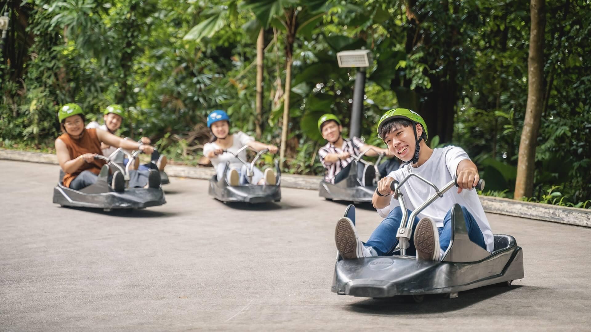 A man leads his friends down the Luge tracks at Skyline Luge Singapore.